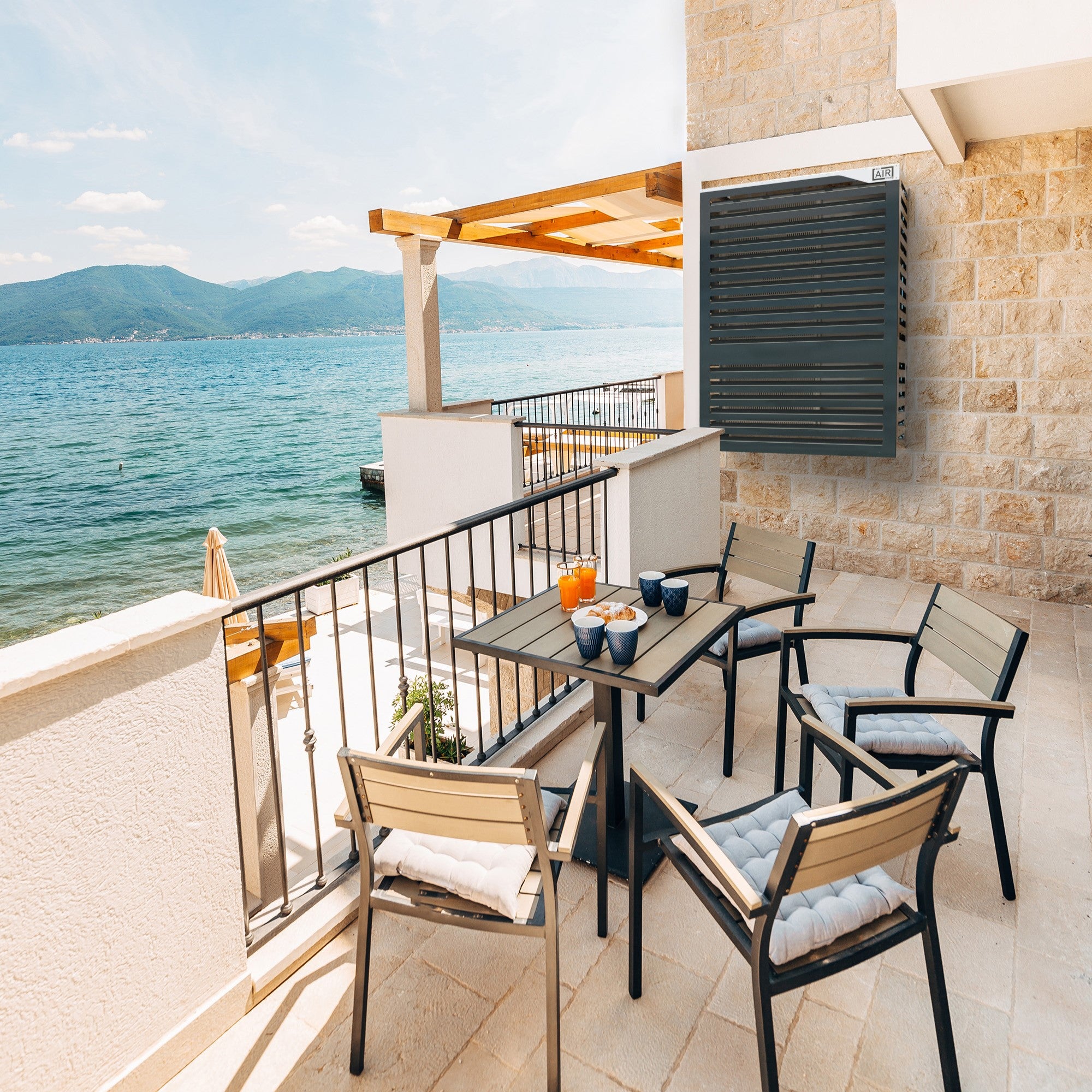 Stylish anthracite heat pump cover on sea-facing luxury Airbnb balcony – breakfast setting, wall-mounted VL unit. ideal integration with PANASONIC CU-TZ60ZKE.