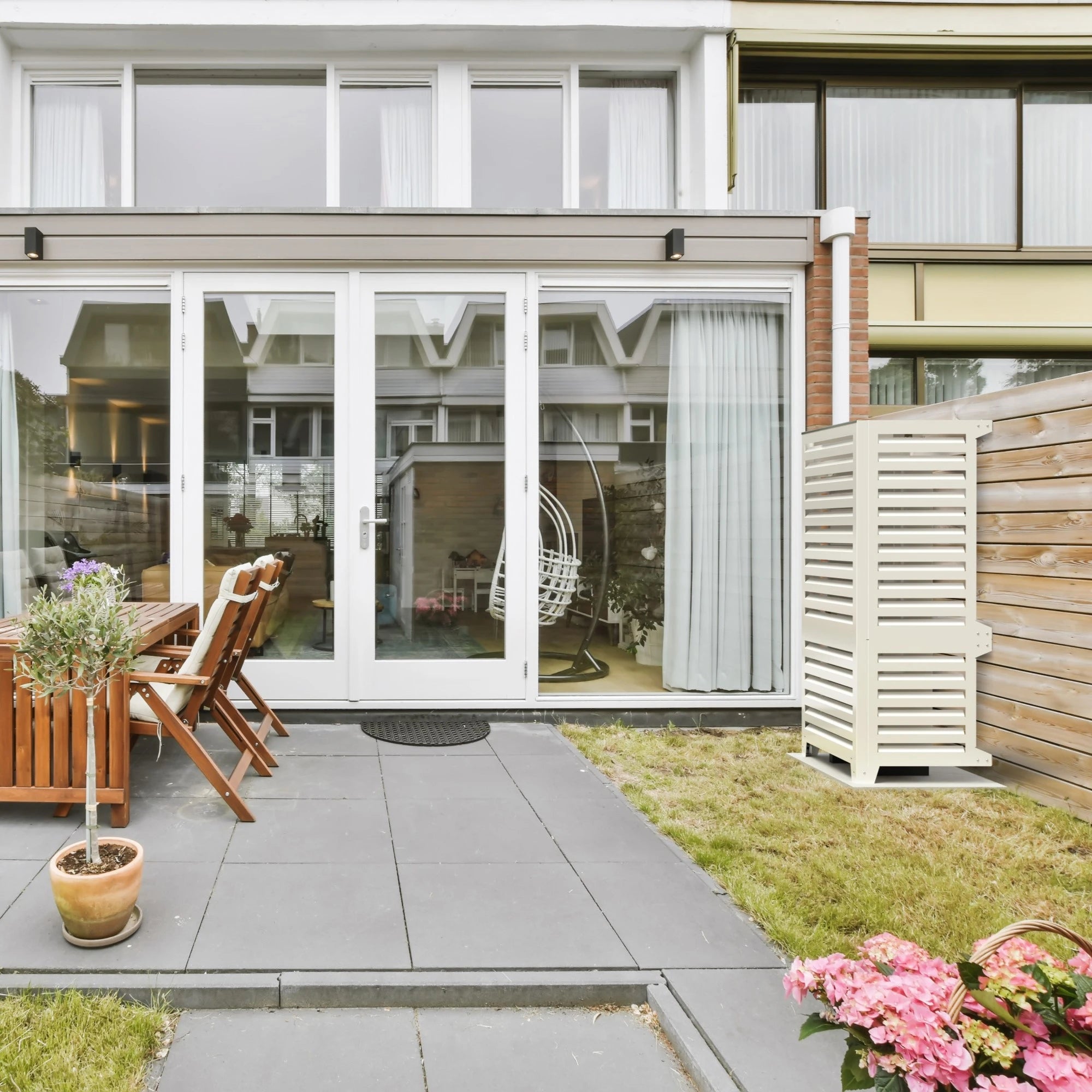 Cache beige pour pompe à chaleur Panasonic WH-UXZ09KE8 en jardin résidentiel, cache l’unité extérieure tout en valorisant la façade.