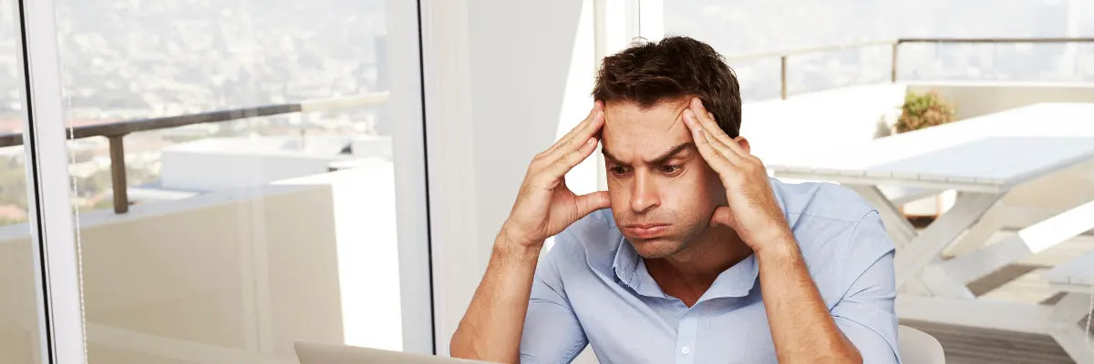 Uomo frustrato davanti al computer per la configurazione complicata della wallbox senza guida o supporto tecnico disponibile