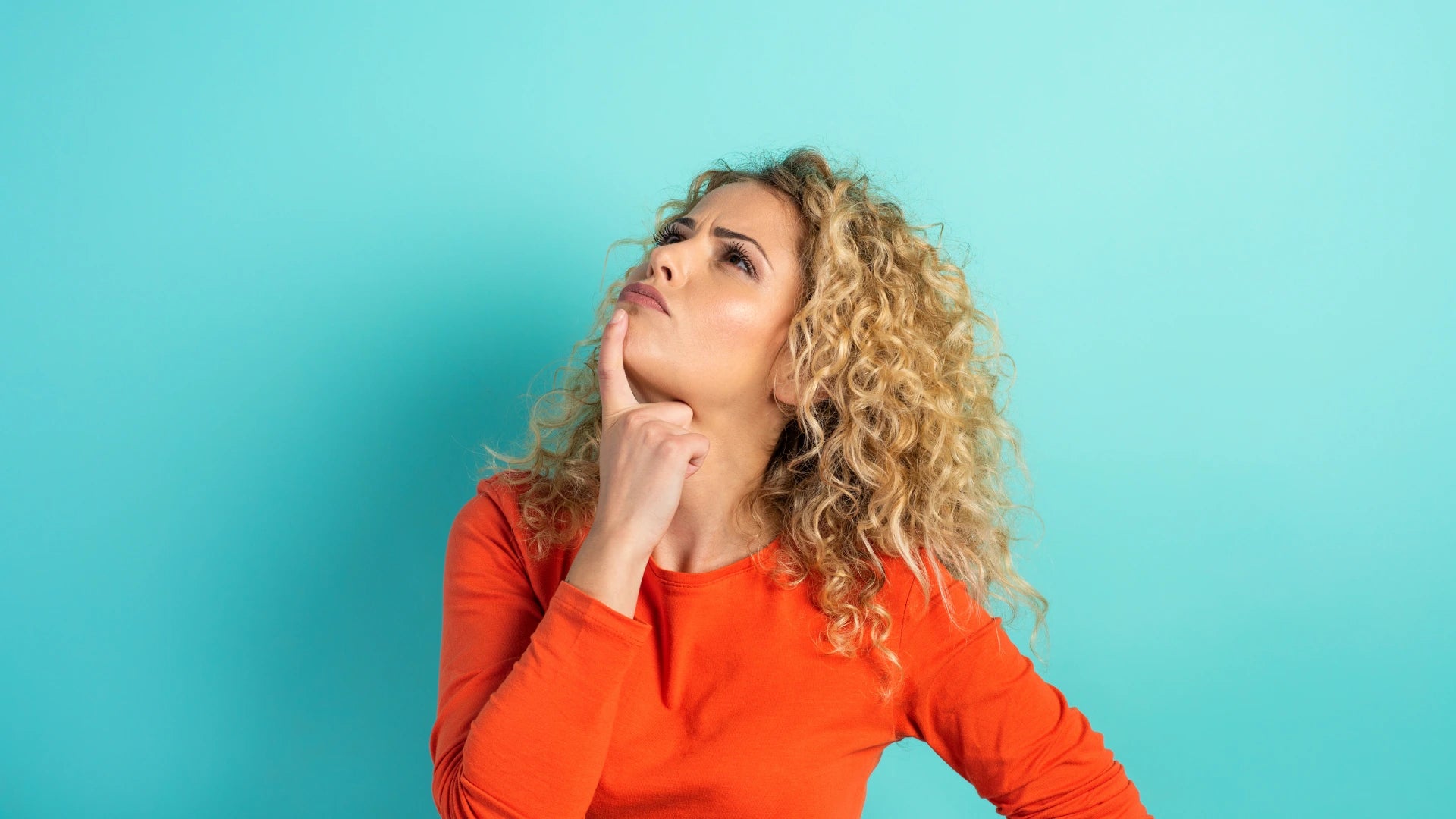 Femme pensive sur fond bleu – visuel utilisé dans un quiz interactif pour choisir la bonne protection ou cache climatiseur.
