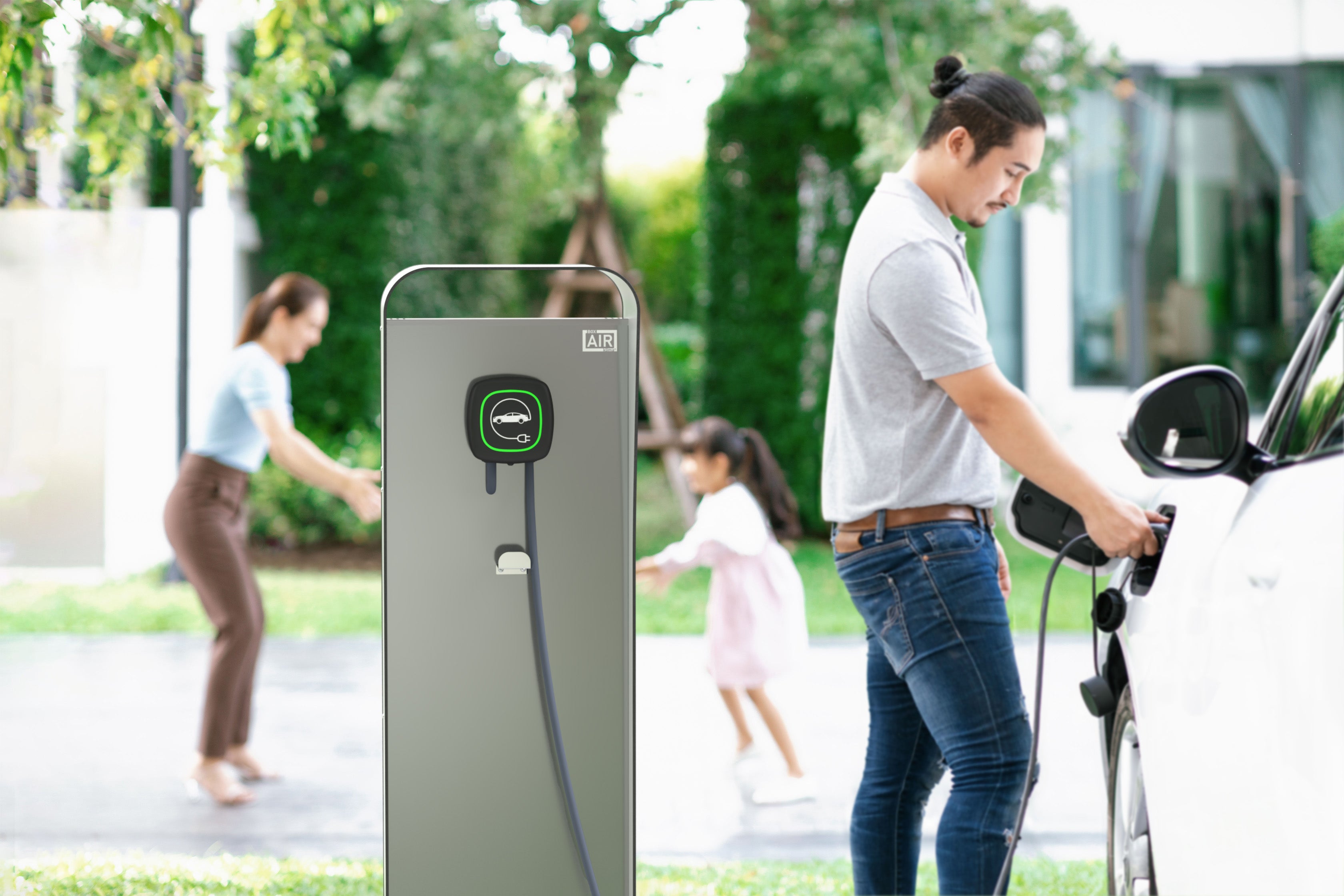 A father charges the EV while kids play – stand installed beside a plant-covered home, combining functional utility and joyful everyday life. Compatible with Easee Base wallbox charging station.