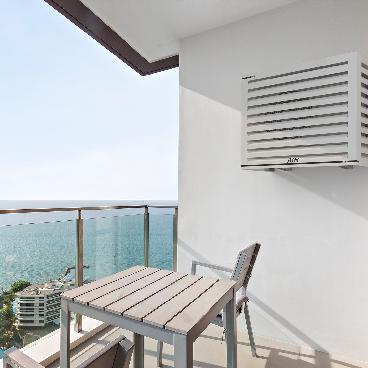 Couverture murale pour climatiseur – design moderne installé sur balcon de maison bord de mer.  Installation sur Toshiba RAS-B13J2KVG-E, modèle extérieur compact et performant.