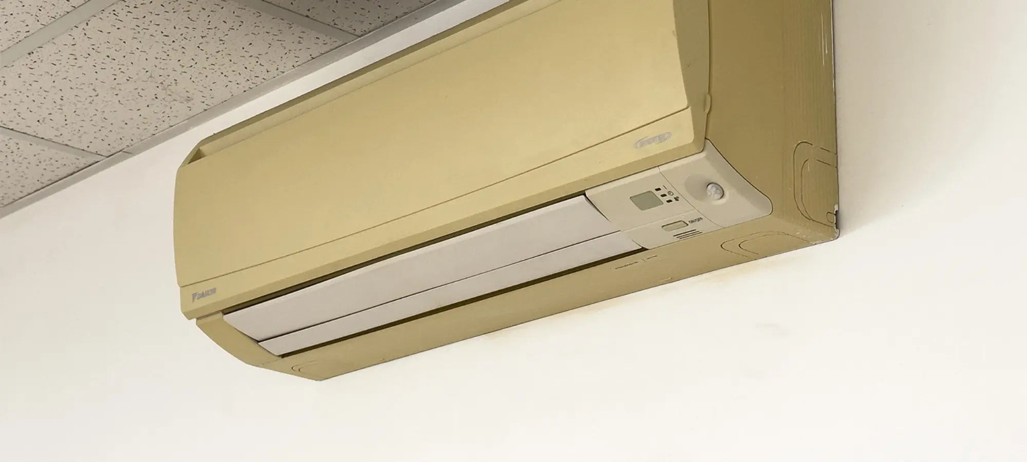 Unité split Daikin jaunie sans cache décoratif, nécessitant une solution esthétique pour harmoniser l’intérieur du séjour
