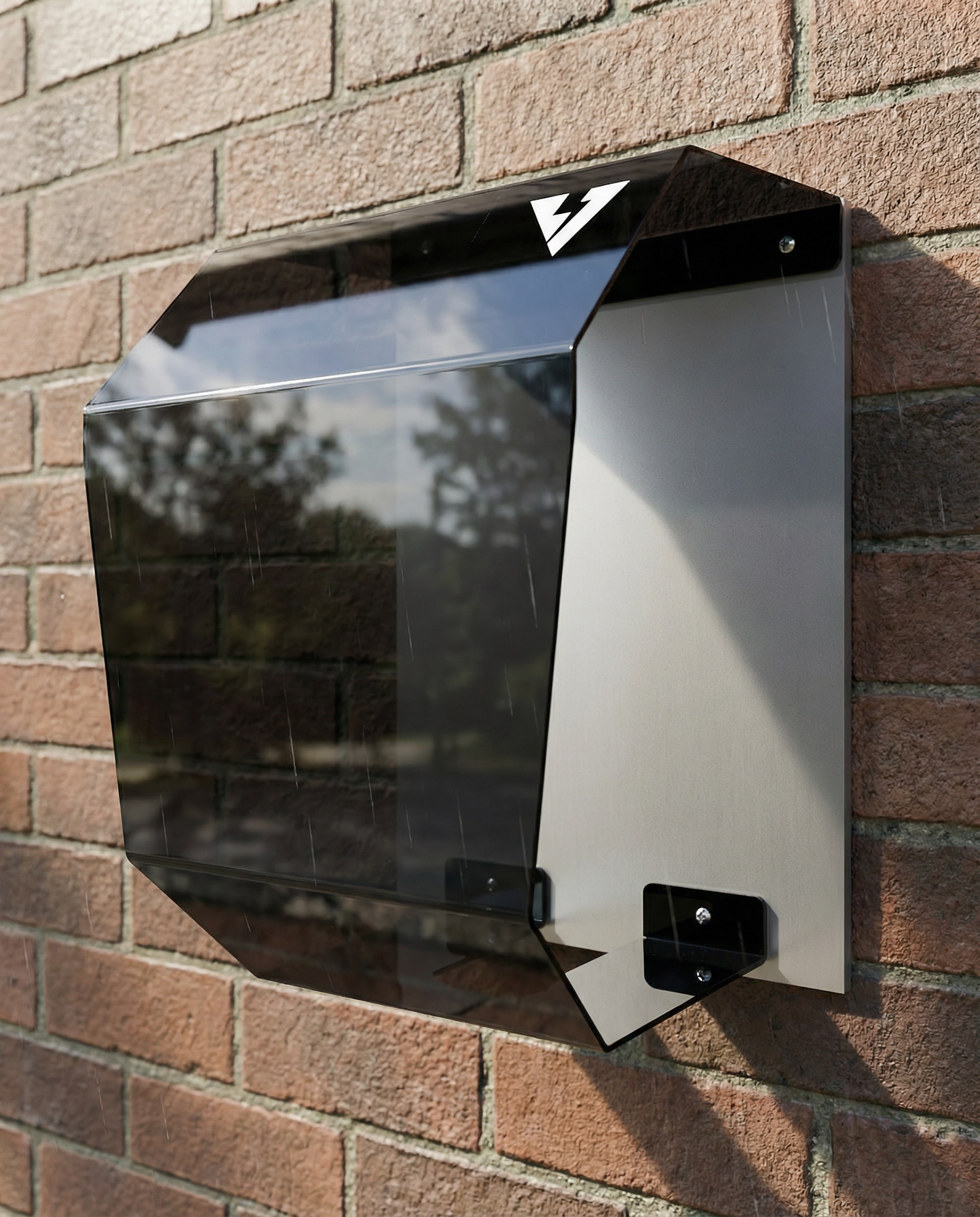 Dettaglio Crystal Shell montato su parete in mattoni: protezione frontale per wallbox con pannello fumé trasparente e struttura posteriore chiara, design moderno per installazione outdoor.