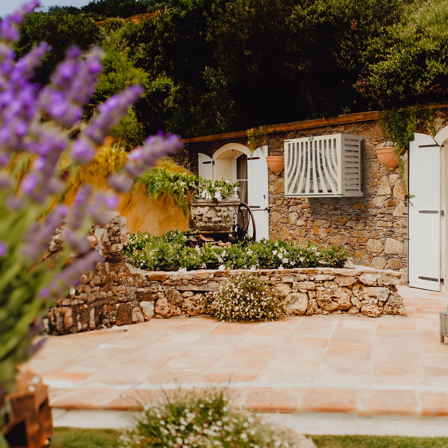 Romantic and protective outdoor AC white cover installed in luxurious Provençal garden. Application sur Hitachi RAS, structure compatible pour optimiser l’espace et protéger l’installation durablement.